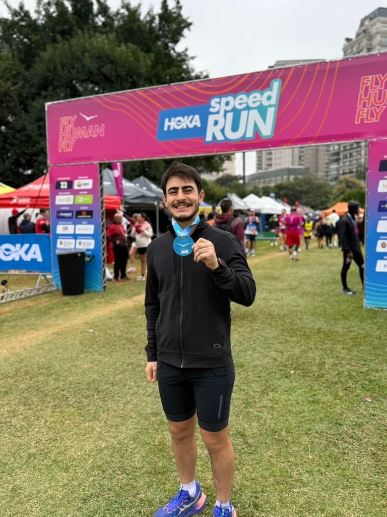 Marcos holding a 30K finisher medal